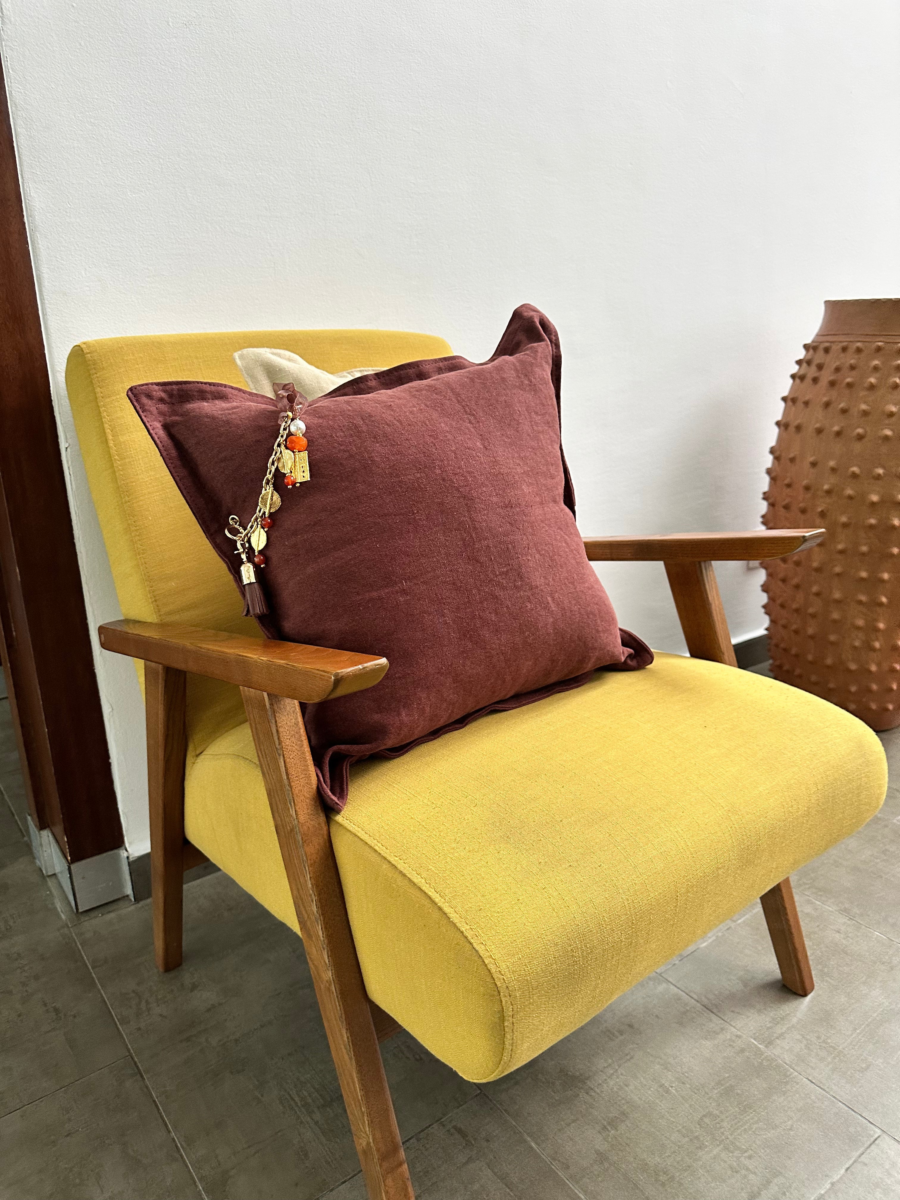Coussin en lin brun posé sur un fauteuil jaune | MIYA