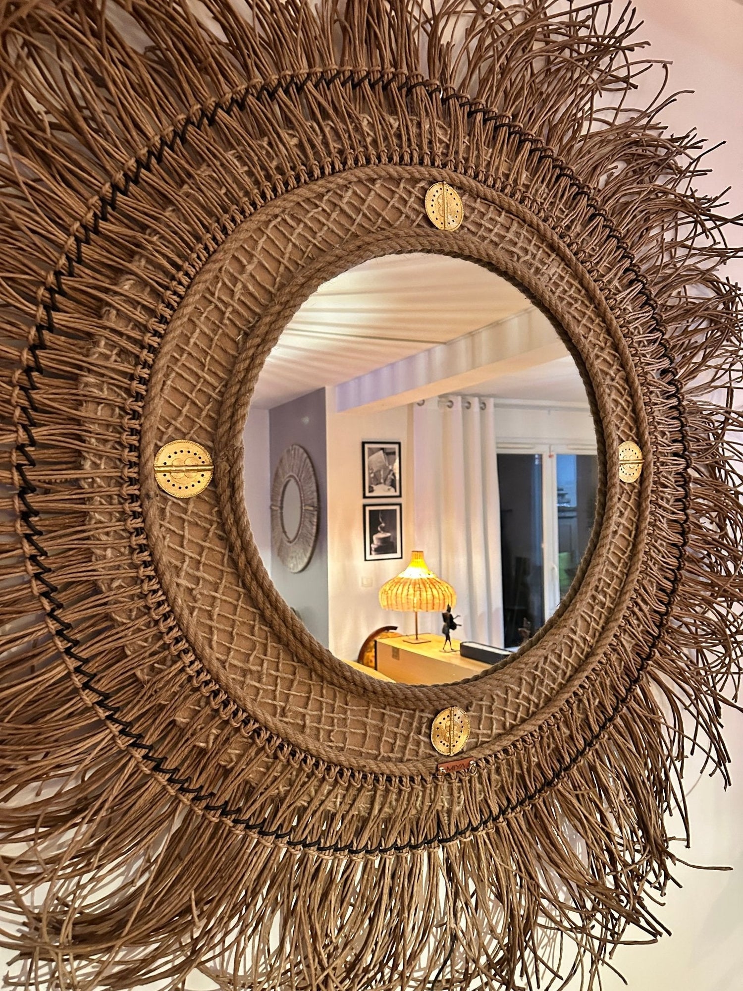 Miroir en fibre naturelle au mur avec lampe en fond