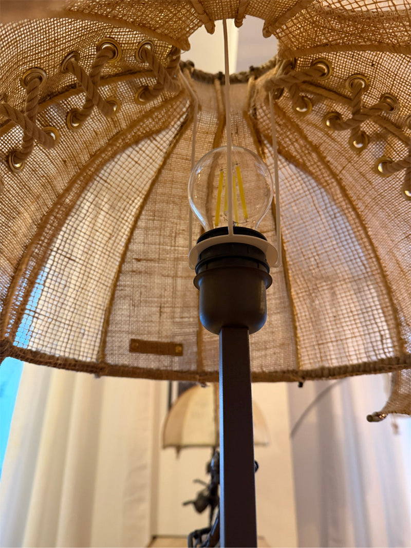 Lampe artisanale MIYA en fibres naturelles avec abat-jour et laçage décoratif laissant apparaître l’ampoule.