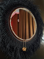 Miroir rond Ebony accroché à un mur dans un lounge - Décoration murale artisanale | MIYA